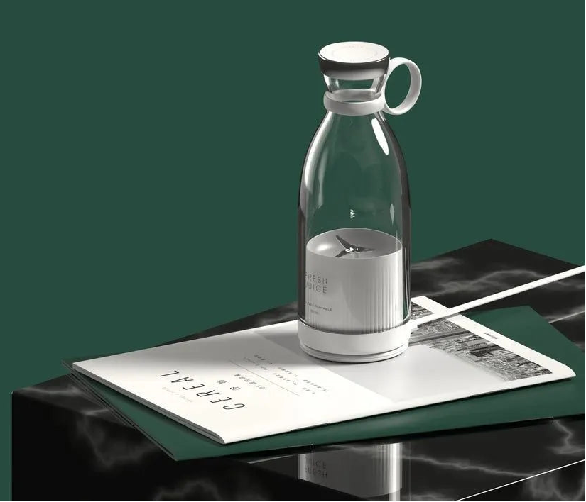 Clear glass carafe with white lid on a dark surface with newspaper