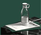 Clear glass carafe with white lid on a dark surface with newspaper